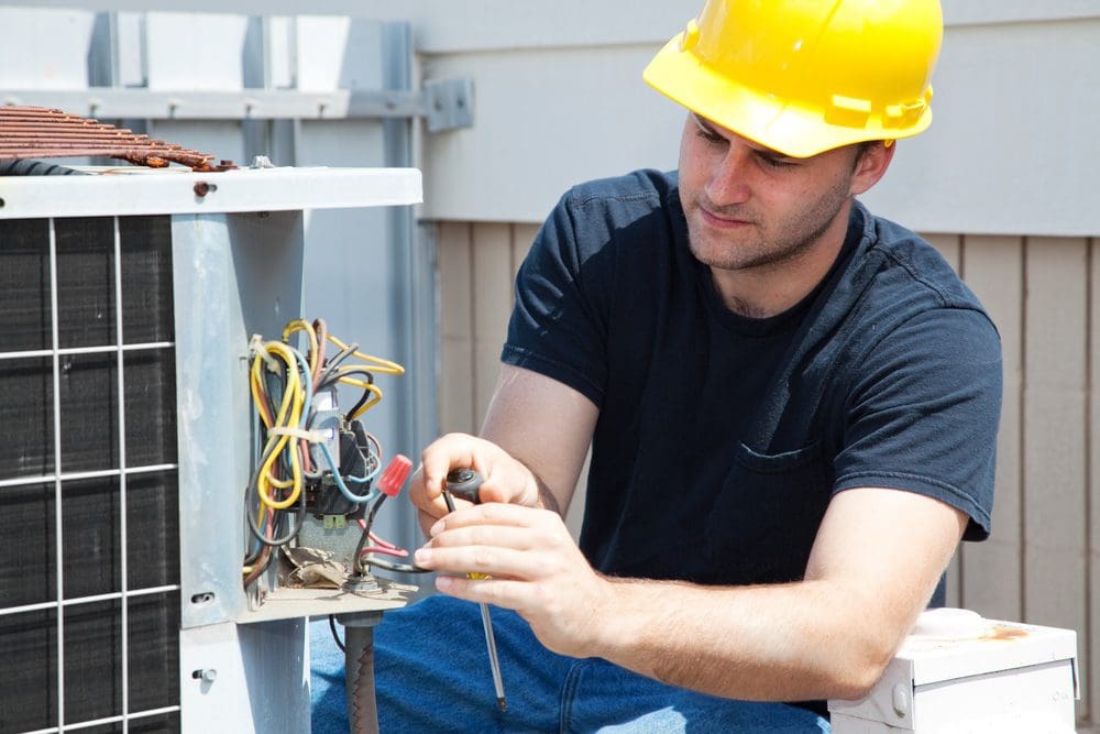 HVAC technician servicing an air conditioning unit